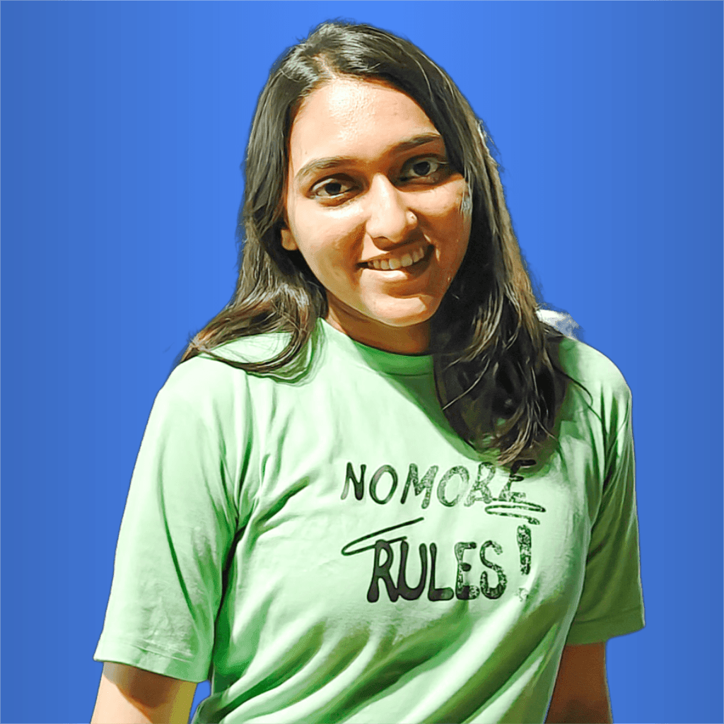 Person wearing a green shirt with the text 'No More Rules!' standing against a blue background.