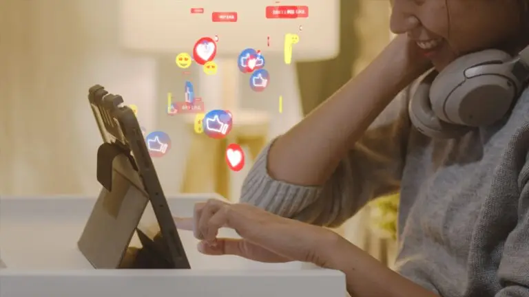 Person with headphones smiles while tapping a tablet on a white stand; floating social icons in red, blue, and yellow rise above.