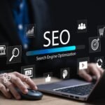 Hands on a laptop with floating SEO icons (magnifier, chart, target, cart, globe, play) and a blue progress bar.