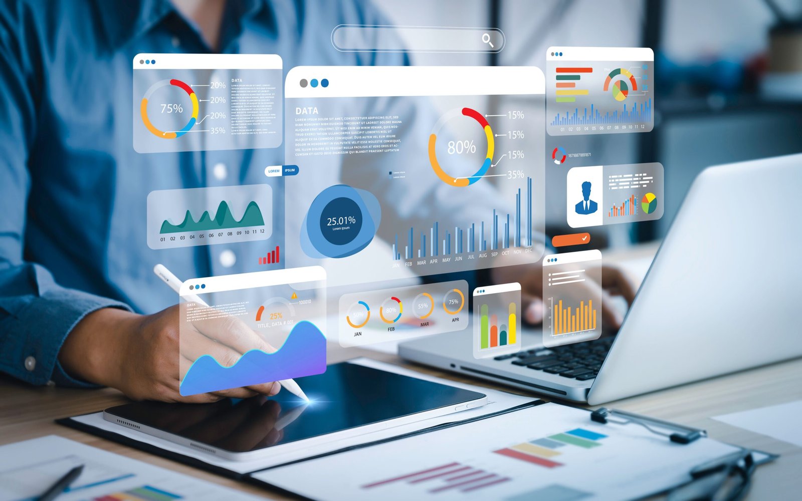 Hands hover over a tablet and laptop with floating analytics dashboards showing pie, bar and line charts in blue, orange and teal.